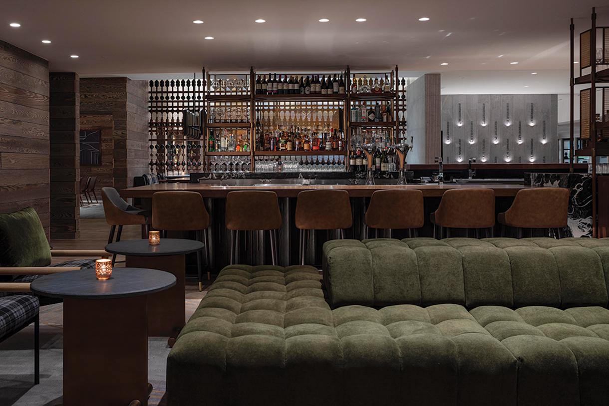 Bar with large green sofa seating area